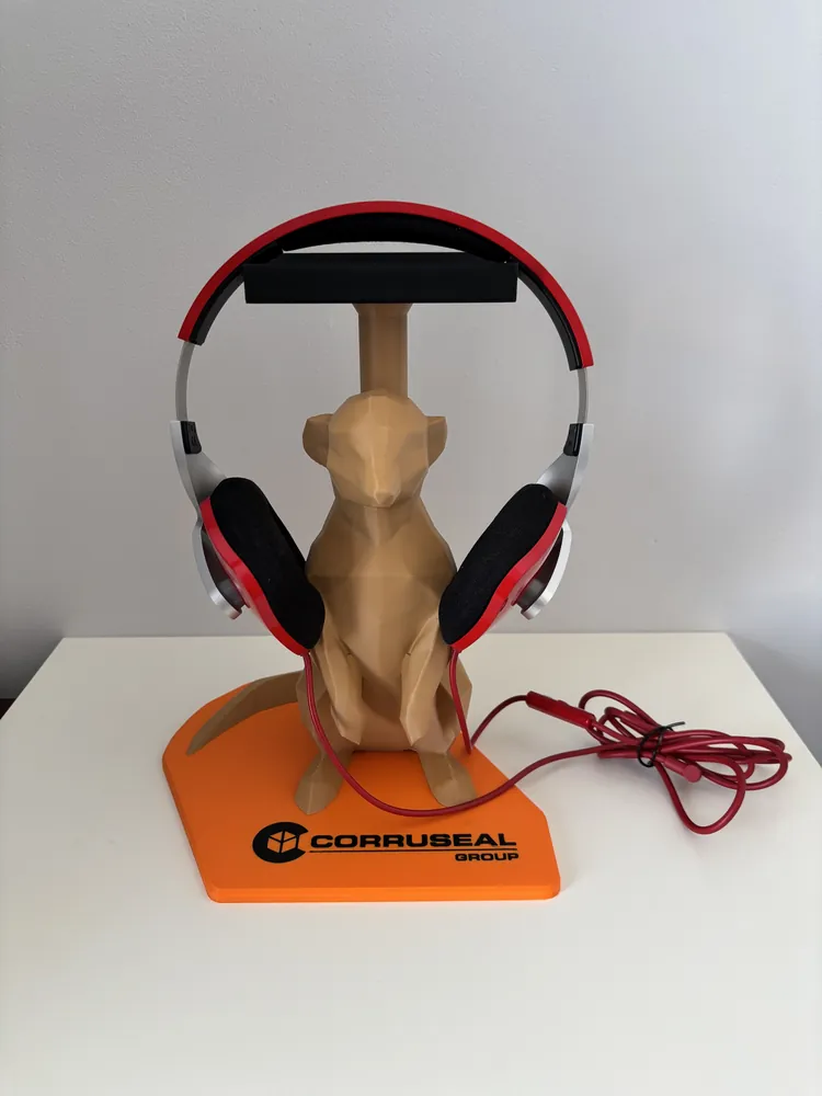 Low-poly meerkat headphone stand holding red headphones, on an orange branded base